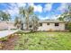 Charming single-story home with a blue door, desert landscaping, and a bright sky above at 821 52Nd S Ave, St Petersburg, FL 33705
