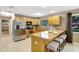 Modern kitchen with an island bar, tile floors, stainless steel appliances, and wooden cabinetry at 821 52Nd S Ave, St Petersburg, FL 33705