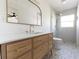 Modern bathroom featuring a wooden vanity, white countertop, decorative mirror and geometric tile floors at 8444 15Th N Way, St Petersburg, FL 33702
