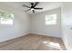 Bright, minimalist bedroom with hardwood floors, two windows, and a ceiling fan at 8444 15Th N Way, St Petersburg, FL 33702