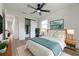 A well-lit bedroom features a large bed, wood floors, ceiling fan, and closet with sliding doors at 8444 15Th N Way, St Petersburg, FL 33702