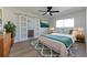 Bright bedroom featuring a king bed, ceiling fan, wood floors, and sliding doors leading to the bathroom at 8444 15Th N Way, St Petersburg, FL 33702