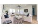 Spacious living room with white armchairs and sofa, a modern ceiling fan, and a large mounted TV at 8444 15Th N Way, St Petersburg, FL 33702