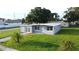 A well-maintained, single-story home with a gray exterior, green lawn and mature trees at 8502 Grapefruit Ave, Tampa, FL 33619