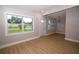 The large living area features wood-look floors, fresh neutral paint, and multiple windows at 8502 Grapefruit Ave, Tampa, FL 33619