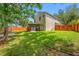 Spacious backyard with green grass, a screened porch, and a wooden fence at 8514 Manassas Rd, Tampa, FL 33635
