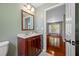 Bathroom featuring a wooden vanity with a light countertop and a glimpse into the adjacent living area at 8514 Manassas Rd, Tampa, FL 33635