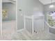 Bright hallway featuring carpeted floors, a window and railing for safety, leading to another room at 8514 Manassas Rd, Tampa, FL 33635