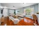 Bright and airy living room featuring hardwood floors, neutral decor, and open access to the kitchen area at 8514 Manassas Rd, Tampa, FL 33635