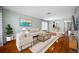 Bright living room with hardwood floors, modern furniture, and a seamless flow into the adjacent dining area at 8514 Manassas Rd, Tampa, FL 33635
