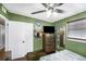 Comfortable bedroom with a large dresser, ceiling fan, closet, and green walls at 8556 91St Ter, Seminole, FL 33777