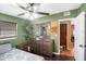 Bedroom with hardwood floors, ceiling fan, a large dresser, and a door to another room at 8556 91St Ter, Seminole, FL 33777