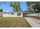 Charming single-story home featuring a covered carport and a well-maintained front yard with a white picket fence at 8556 91St Ter, Seminole, FL 33777