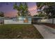 Charming single-story home featuring a covered carport and a well-maintained front yard with a white picket fence at 8556 91St Ter, Seminole, FL 33777