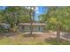Charming single-story home with a metal roof, mature landscaping, and a fenced front yard at 9213 W Robson St, Tampa, FL 33615