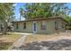 Quaint single-story home featuring light green siding, a front-facing entrance, and small windows at 9213 W Robson St, Tampa, FL 33615