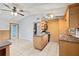 Kitchen features an island cooktop, light wood cabinets, tile flooring, and an eat-in area with exterior access at 9213 W Robson St, Tampa, FL 33615