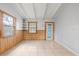 Bright living room featuring white walls, tile flooring, wood paneled accent walls, and an exterior door at 9213 W Robson St, Tampa, FL 33615