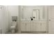 Bathroom boasting a dual sink vanity, framed mirror, white toilet, and shower with white shower curtain at 9604 Runaway Breeze Dr, Land O Lakes, FL 34637