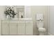 Bathroom featuring a toilet, a spacious vanity, framed mirror and a stand-up shower with clear glass doors at 9604 Runaway Breeze Dr, Land O Lakes, FL 34637