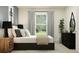 Bright bedroom showcasing a modern bed with sleek gray curtains and a view to the outside at 9604 Runaway Breeze Dr, Land O Lakes, FL 34637
