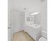 Bright bathroom with double sink vanity, modern lighting, and tiled floors at 9731 Meadow Field Cir, Tampa, FL 33626