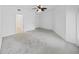 Spacious bedroom features neutral carpeting, modern fan, closet, and a door leading to the bathroom at 9731 Meadow Field Cir, Tampa, FL 33626