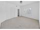 An empty bedroom boasts neutral carpeting, ceiling fan, a large window with shutters, and a view to an open closet at 9731 Meadow Field Cir, Tampa, FL 33626