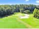 Scenic golf course view with lush green fairways, sand trap, and mature trees at 9731 Meadow Field Cir, Tampa, FL 33626