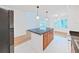 Open-concept kitchen flows into the living area, featuring a granite island, stainless appliances, and ample light at 9731 Meadow Field Cir, Tampa, FL 33626