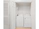 Bright laundry closet features a stacked washer and dryer, shelving, and ample storage space behind white bi-fold doors at 9731 Meadow Field Cir, Tampa, FL 33626