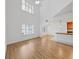 Bright living room with vaulted ceiling featuring large windows with plantation shutters and kitchen view at 9731 Meadow Field Cir, Tampa, FL 33626