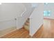 Bright and airy staircase featuring hardwood floors and white walls, leading to the upper level at 9731 Meadow Field Cir, Tampa, FL 33626