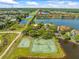 Aerial view showcasing community amenities including tennis and basketball courts at 9842 Lake Chase Island Way, Tampa, FL 33626
