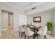 Bright dining area with a table set for six, light wood floors, and adjacent access to another room at 9842 Lake Chase Island Way, Tampa, FL 33626