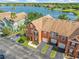 Aerial view of colorful townhomes with attached garages near a serene lake at 9842 Lake Chase Island Way, Tampa, FL 33626