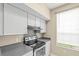 Well-equipped kitchen featuring stainless steel appliances, gray backsplash, and a bright window at 9842 Lake Chase Island Way, Tampa, FL 33626