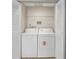 Convenient laundry area featuring a white washer and dryer with overhead shelving at 9842 Lake Chase Island Way, Tampa, FL 33626
