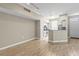Open-concept living space with wood-look floors seamlessly connecting to the kitchen area at 9842 Lake Chase Island Way, Tampa, FL 33626
