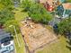 Aerial view of the community playground with slides, swings, and benches surrounded by trees at 9842 Lake Chase Island Way, Tampa, FL 33626