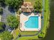 Aerial view of heart-shaped community pool, surrounded by trees and parking at 9842 Lake Chase Island Way, Tampa, FL 33626