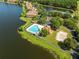 Aerial of community pool and sand volleyball court alongside a beautiful lake at 9842 Lake Chase Island Way, Tampa, FL 33626