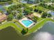 Aerial view of heart-shaped community pool and amenities by the lake at 9842 Lake Chase Island Way, Tampa, FL 33626