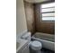 Clean bathroom with a tiled shower-tub combination, a toilet, and a vanity at 9902 N Myrtle St, Tampa, FL 33617