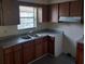 Functional kitchen with wood cabinets, a dual basin sink, and ample counter space at 9902 N Myrtle St, Tampa, FL 33617