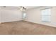 Spacious bedroom with neutral carpet, ceiling fan, and bright windows at 10847 Kirkwall Port Dr, Wimauma, FL 33598