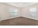 Bright bedroom featuring dual windows and neutral carpet at 10847 Kirkwall Port Dr, Wimauma, FL 33598