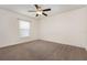 Carpeted bedroom featuring a ceiling fan and a bright window at 10847 Kirkwall Port Dr, Wimauma, FL 33598