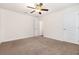 Large carpeted bedroom with ceiling fan and ensuite bathroom at 10847 Kirkwall Port Dr, Wimauma, FL 33598