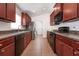 Modern kitchen featuring dark wood cabinets and tile flooring at 10847 Kirkwall Port Dr, Wimauma, FL 33598